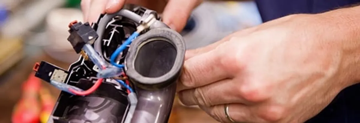 Vacuum repair technician reconnecting wiring and components in Oklahoma City, OK