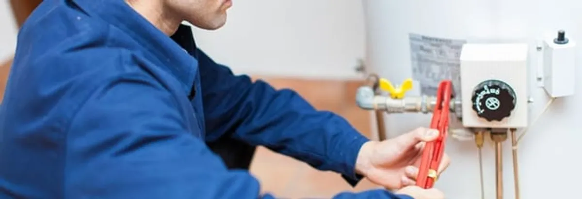 Water heater repair technician adjusting the temperature control and gas valve in Oklahoma City, OK